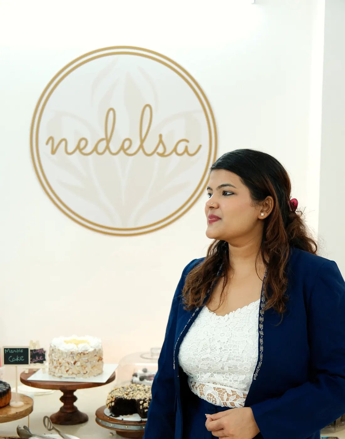 Sona standing behind two finished celebration cakes at the Nedelsa studio