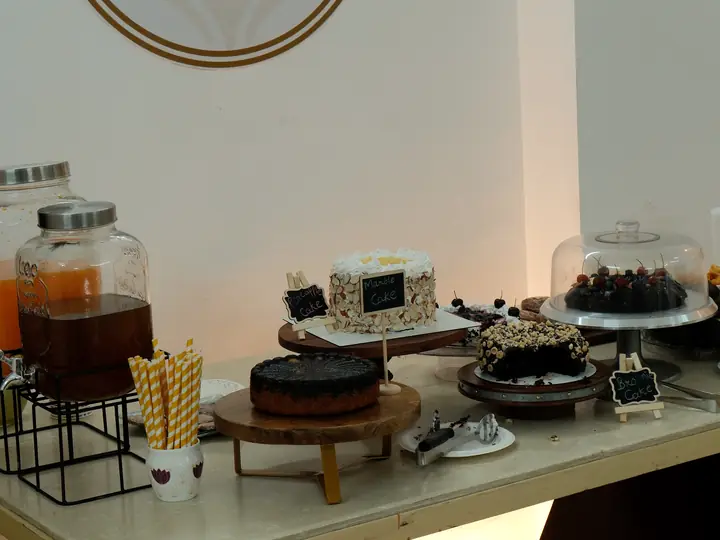 The dessert table laid out beneath the gold Nedelsa mark on the studio wall