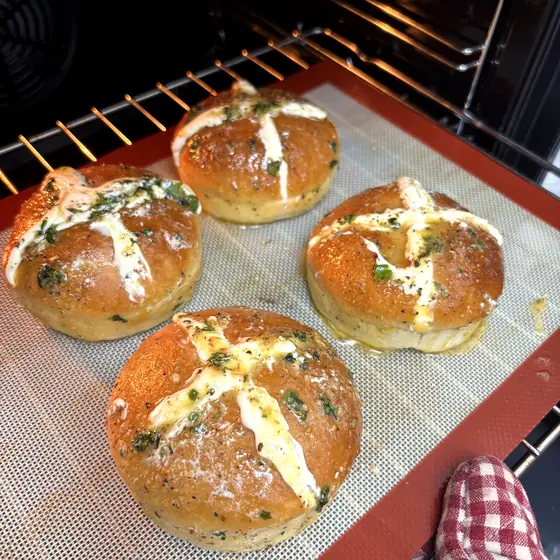 Korean cream cheese garlic buns baking on a tray inside the studio oven