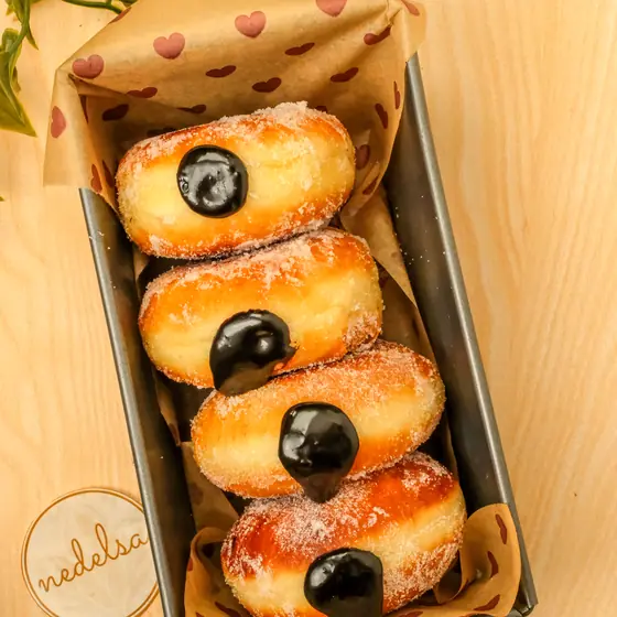 Four sugared cream-filled doughnuts in a lined tin with the Nedelsa mark